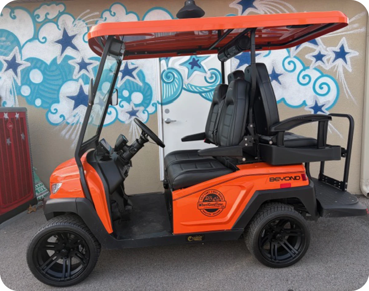 Orange golf cart with street art background.
